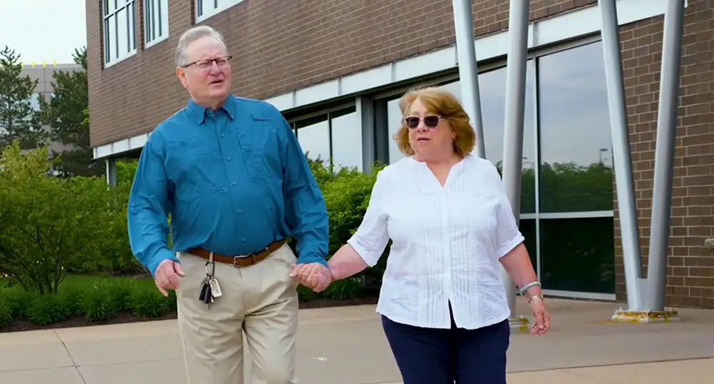 Older man and woman walk hand-in-hand