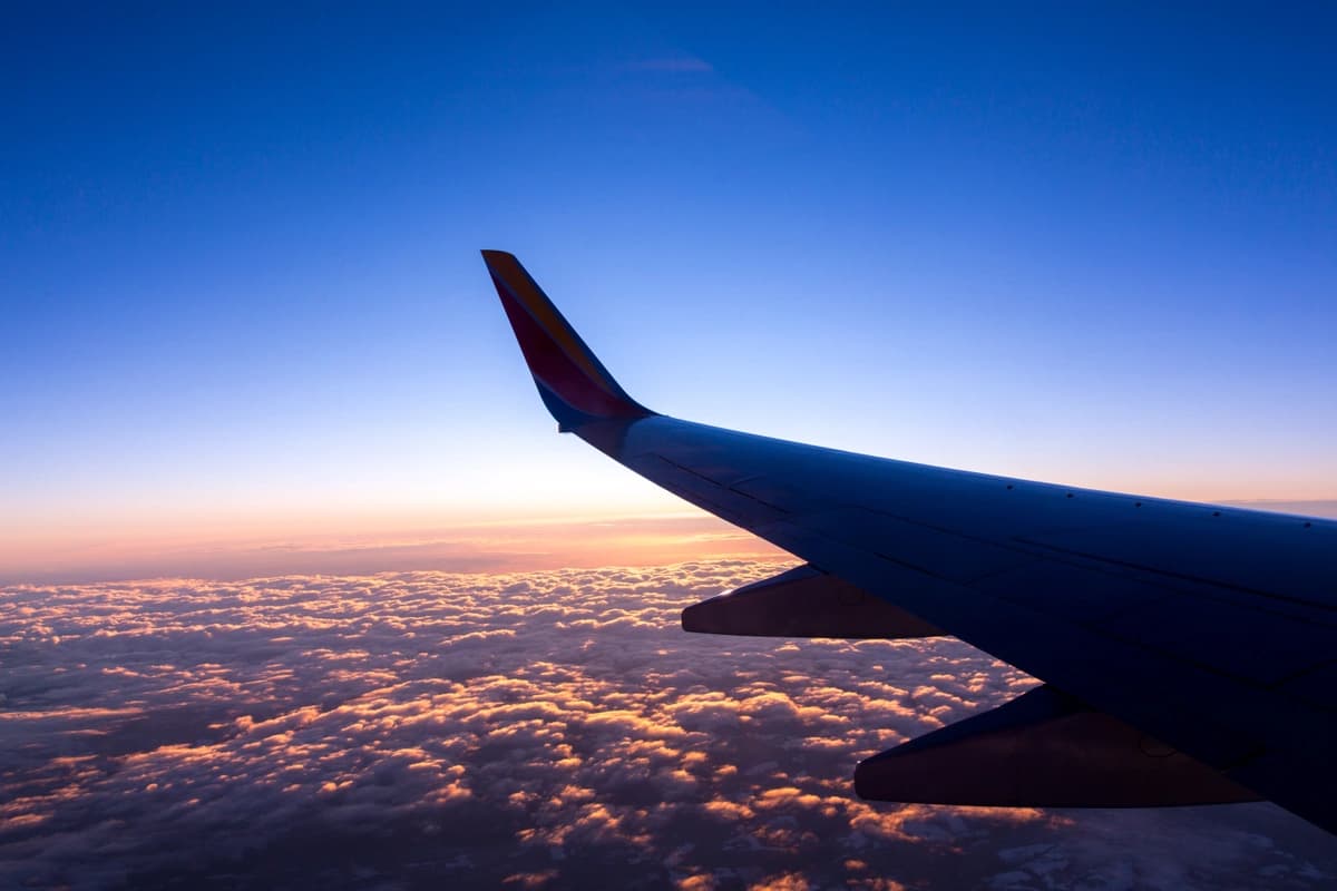 The wing of an airplane as it flies over the clouds