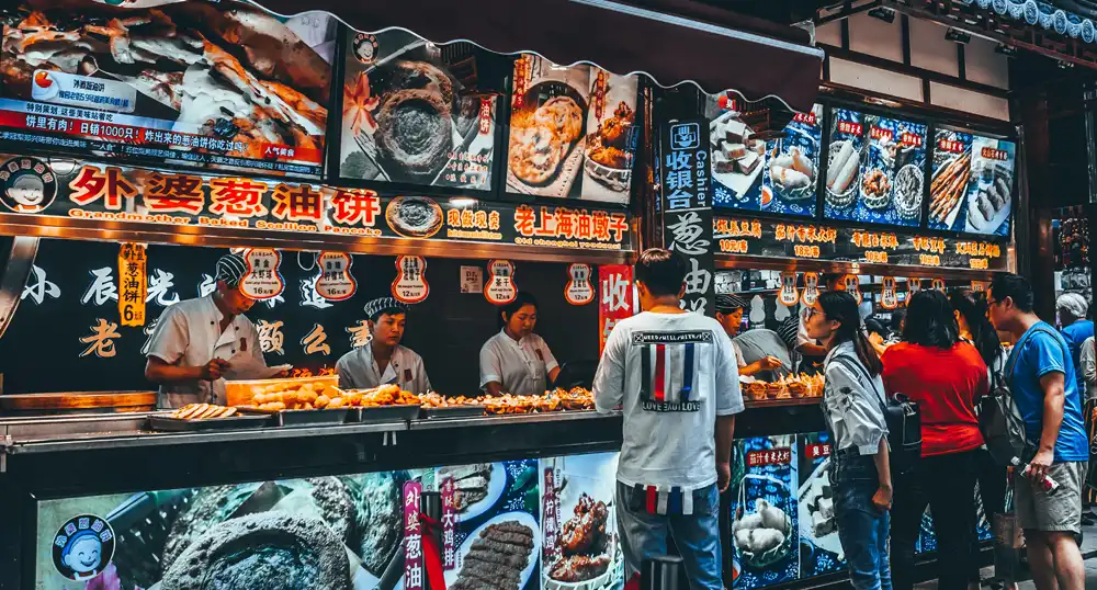 Customers buy food at a market counter in Asia